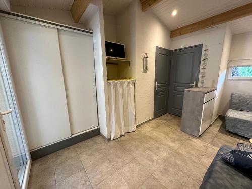 Cette chambre dispose d'une porte, d'un canapé et d'une télévision. dans l'établissement Marseillan Plage studio indépendant, à Marseillan