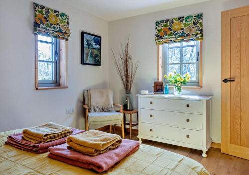 a bedroom with a bed and a dresser and windows at Patagonia in Builth Road