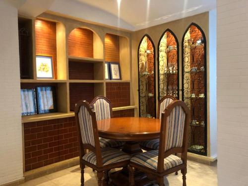 a dining room with a table and chairs and stained glass windows at Como en casa 1 in Elche