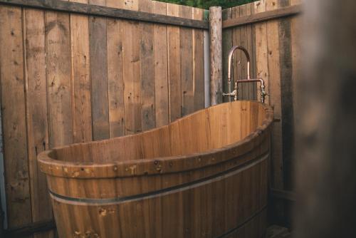 una bañera de madera junto a una valla de madera en Bygagergaard, en Askeby