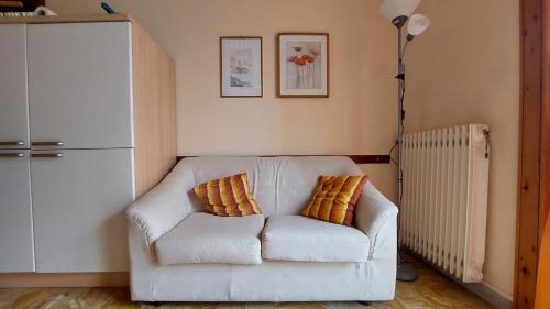 ein Wohnzimmer mit einer weißen Couch mit zwei Kissen in der Unterkunft AlbengaMare in Albenga