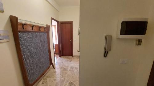 einen Flur mit Tür und TV an der Wand in der Unterkunft AlbengaMare in Albenga