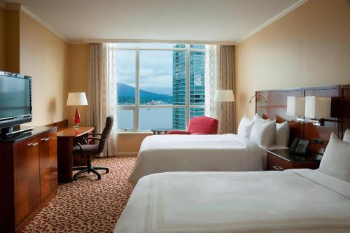 a hotel room with two beds and a television at Vancouver Marriott Pinnacle Downtown Hotel in Vancouver