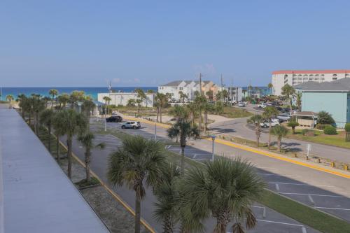 a view of a street with palm trees and the ocean at SeaCrest 413 condo in Fort Walton Beach