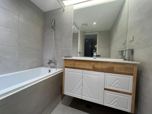 uma casa de banho com uma banheira branca e um lavatório. em Kaohsiung Ahotel em Kaohsiung
