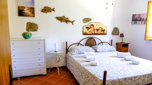 a bedroom with a bed and a dresser at La Casa dei due Ulivi in Capo dʼOrlando