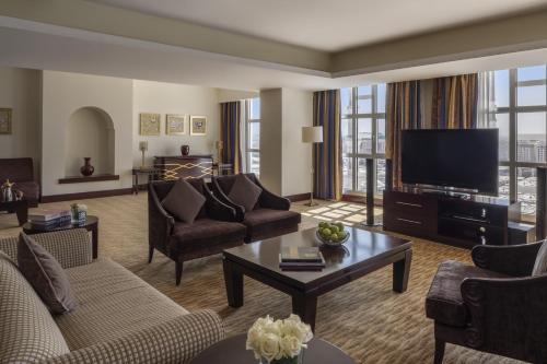 a living room with couches and a flat screen tv at Anwar Al Madinah Mövenpick in Al Madinah