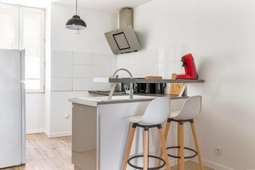 - une cuisine avec un évier et deux tabourets de bar blancs dans l'établissement WhiteHorse 2 CahorsCityStay, à Cahors