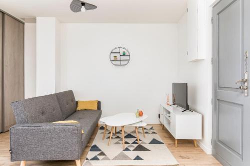 un salon avec un canapé et une table dans l'établissement WhiteHorse 2 CahorsCityStay, à Cahors