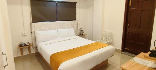 a bedroom with a large white bed with a window at MOCAHM in Shillong