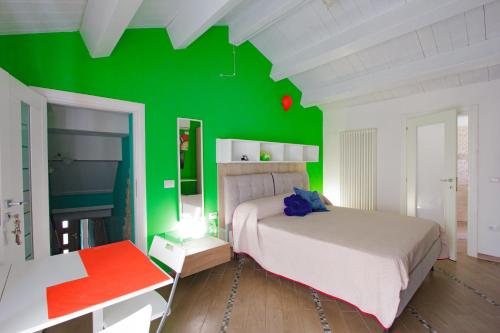 a bedroom with a green wall and a bed at Eden Lilli B&B in La Pieve