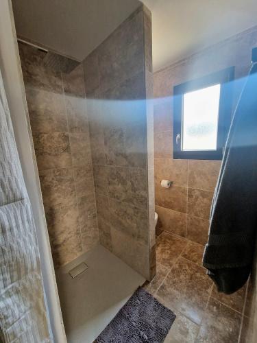 a shower with a glass door in a bathroom at Plages et Terres in Bessan