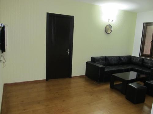 a living room with a couch and a black door at Guesthouse Mtskheta-Kapanadze in Mtskheta