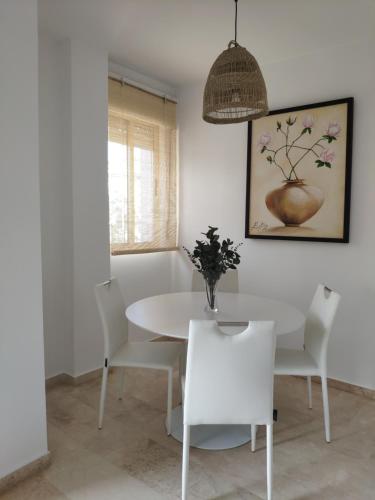 een witte eetkamer met een witte tafel en stoelen bij Pisito del Sol in Algarrobo-Costa
