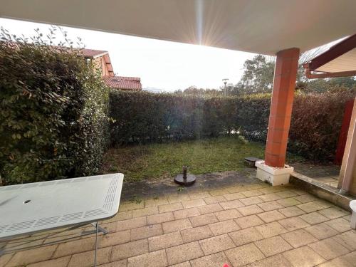 un banc blanc assis sur une terrasse dans une cour dans l'établissement Appartement dans résidence calme, à Capbreton