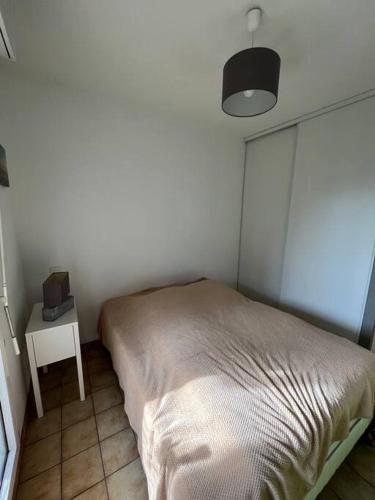 une chambre avec un lit et une table avec une lampe dans l'établissement Appartement dans résidence calme, à Capbreton