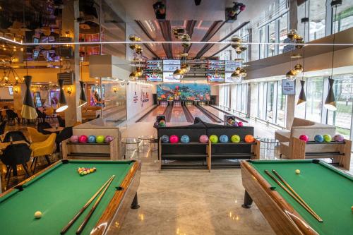 a billiard room with two pool tables and bowling lanes at Aquapark Health Resort & Medical SPA Panorama Morska All Inclusive in Jarosławiec