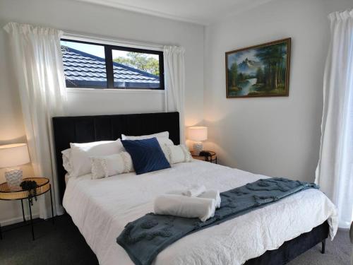 1 dormitorio con 1 cama grande y ventana en Beautiful home near everything! en Christchurch