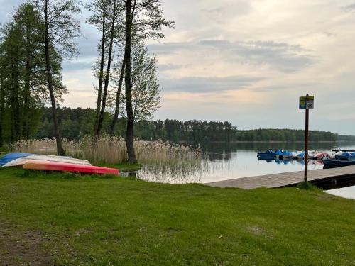 a group of boats are docked at a dock on a lake at Apartament Comfort w Kujankach nad jeziorem in Kujanki