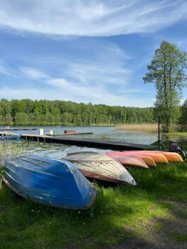 a row of boats parked next to a lake at Apartament Comfort w Kujankach nad jeziorem in Kujanki