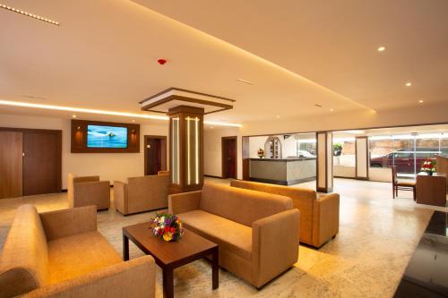 Una sala de estar con sofás y una mesa. en Hotel Keerthi, en Trivandrum