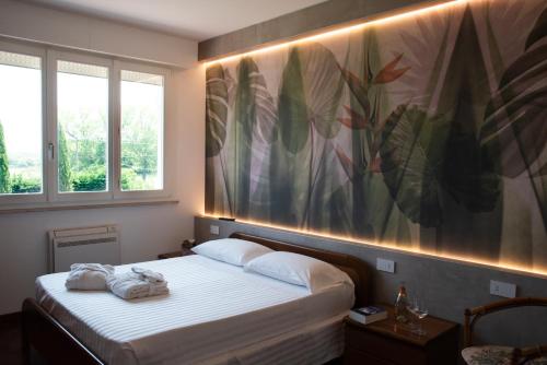 een slaapkamer met een bed met een groot schilderij aan de muur bij CasaLO' Igea in Bellaria-Igea Marina