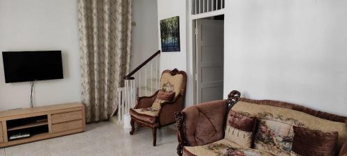 a living room with two chairs and a television at Apartment in Dar Homestay in Dar es Salaam