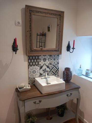 une salle de bain avec un lavabo et un miroir dans l'établissement Les Allumettes d'Ecorsaint, à Écorsain