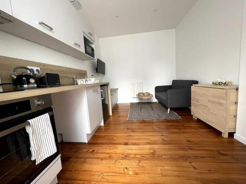 uma sala de estar com um sofá e uma cozinha em Les Suites Paloises - Appt. 4 : Le Parc Beaumont em Pau
