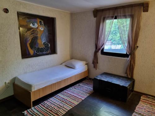 een kleine slaapkamer met een bed en een raam bij Magic Garden Bungalow in Vama Veche