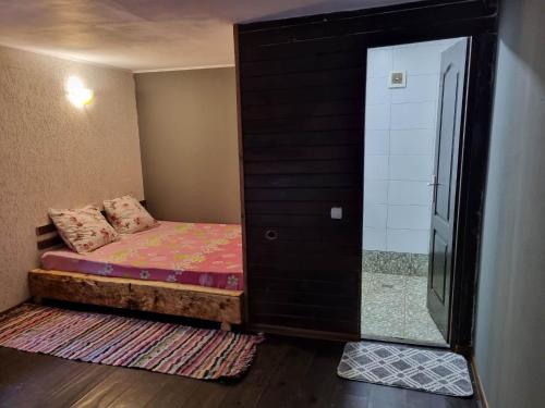 een kleine kamer met een bed en een glazen deur bij Magic Garden Bungalow in Vama Veche