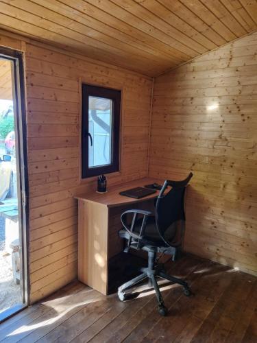 een lege kamer met een bureau en een stoel in een hut bij Magic Garden Bungalow in Vama Veche