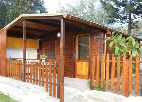 una cabaña de madera con una valla delante en CAMPING MADDALENA, en Palinuro