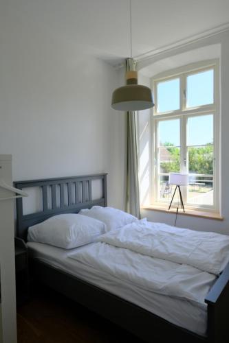 a bedroom with a large bed with a window at Gutshaus FeWo Lübeck in Dassow