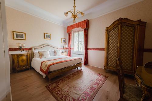 a bedroom with a bed and a chandelier at Castello Di Spessa - Residenze d'epoca in Capriva del Friuli