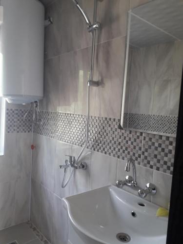 ein Bad mit einem Waschbecken und einem Spiegel in der Unterkunft LenNy 2 in Kranewo