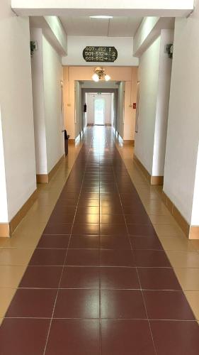 an empty hallway in a building with a tile floor at Thaen Thong Hotel in Lamphun