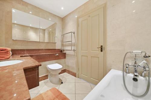 ein Badezimmer mit einer Badewanne, einem WC und einem Waschbecken in der Unterkunft Three Bedroom Apartment in Sloane Square in London