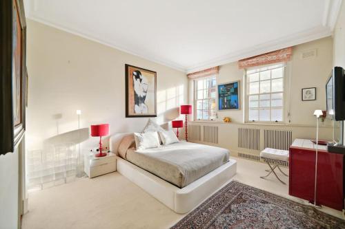 ein Schlafzimmer mit einem Bett und einem TV in der Unterkunft Three Bedroom Apartment in Sloane Square in London