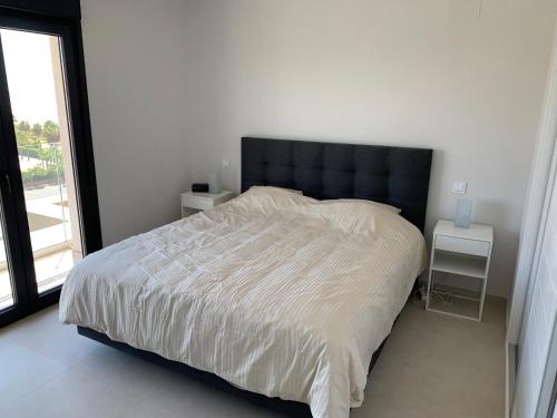 a bedroom with a large bed with a large window at Penthouse with wide terrace next to the ocean in Huelva