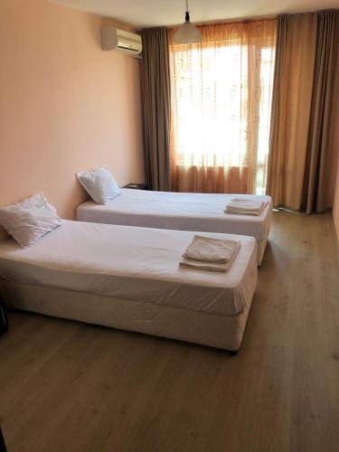 2 bedden in een hotelkamer met een raam bij Anfid Apartments in Boergas