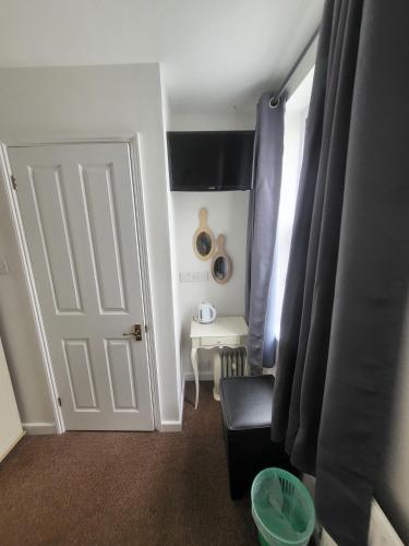 a room with a door and a chair and a table at St Georges Guest House in St Peter Port