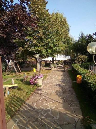 a stone path in a garden with trees and flowers at L’agrifoglio in Francavilla in Sinni