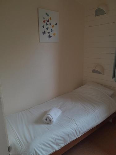 uma cama branca num canto de um quarto em VVF Lac d'Eguzon em Éguzon-Chantôme