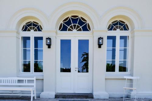 a white house with a white door and a white bench at Gutshaus FeWo Priwall in Dassow
