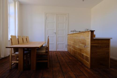 a dining room with a wooden table and chairs at Gutshaus FeWo Priwall in Dassow