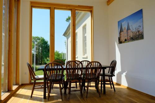 a dining room with a table and chairs and a window at Gutshaus FeWo Priwall in Dassow