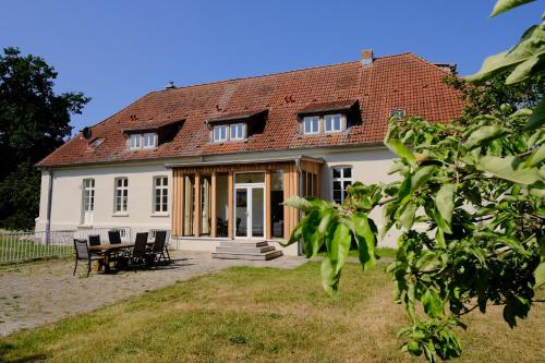 a white house with a table and chairs at Gutshaus FeWo Priwall in Dassow