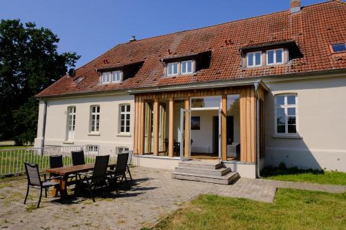 a house with a table and chairs in front of it at Gutshaus FeWo Priwall in Dassow