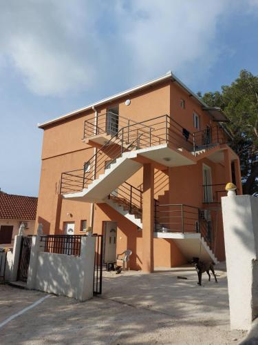 a building with stairs and a dog in front of it at Crni Bor Sutomore in Sutomore